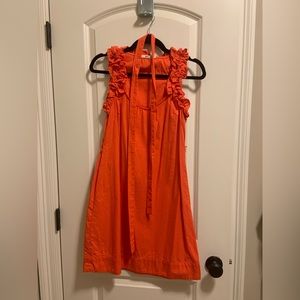 Orange swing dress with belt and ruffle detail around neck.